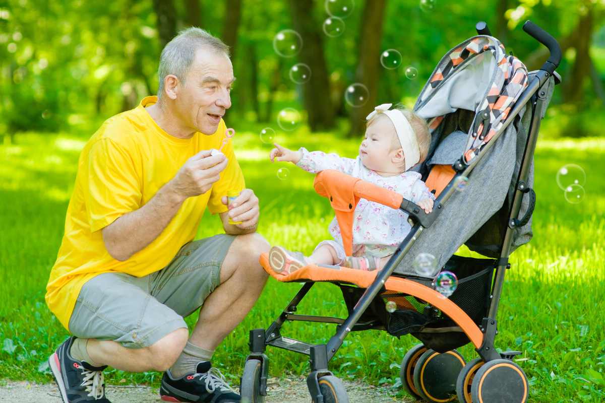 Grandfather blowing bubbles with grandaughter